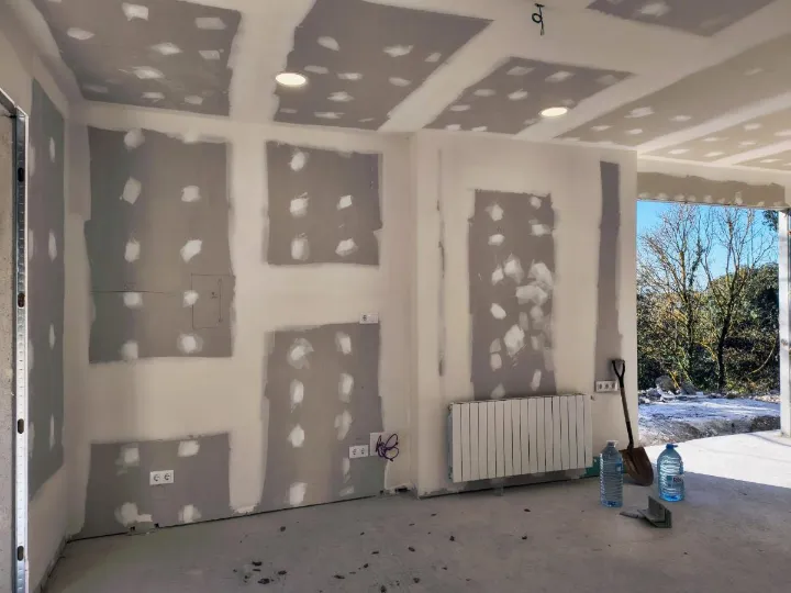 Sala abierta al jardín con falso techo y luz empotrada terminados